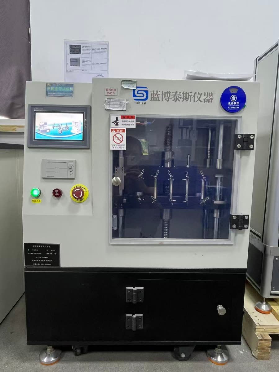Fatigue testing machine running a cycle test on a shaped spring